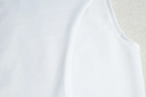 Close-up of white knit fabric texture and high-quality stitching on the bodycon dress