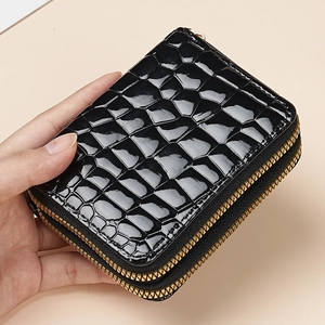 Black crocodile pattern double zipper card holder in glossy leather held by hand