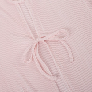Detail of pink pleated fabric texture with elegant ribbon tie bow on short shirt