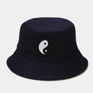 Détail de la broderie symbole yin-yang sur un chapeau bob en coton bleu marine