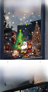 Close-up of Christmas window decals featuring Santa, reindeer, and snowflakes on glass