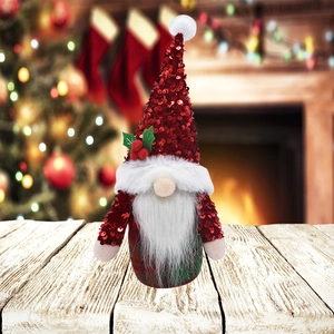Gnome de Noël avec bonnet à paillettes rouges et corps à carreaux verts sur une table en bois