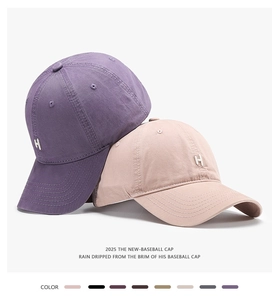 Detail of embroidered H logo on cotton baseball caps in purple and beige tones