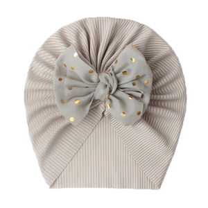 Detail of baby turban hat with ribbed knit fabric and grey mesh bow with gold dots