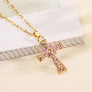 18K gold plated cross pendant necklace with purple enamel and zircon on a white book