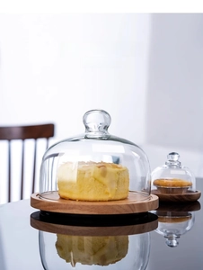 Detail of acacia wood cake stands with glass lids in two sizes for elegant dessert display
