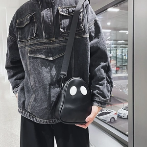 Close-up of ghost-shaped black PU leather bag with white eye patches and adjustable strap