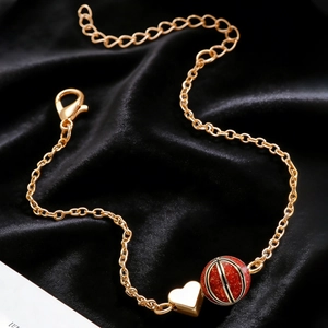Détail du collier cœur doré avec pendentif basket à paillettes rouges sur velours noir