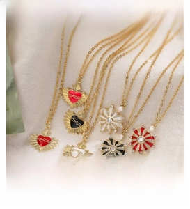 Detail of gold heart and starburst pendants with colorful enamel and zircon stones
