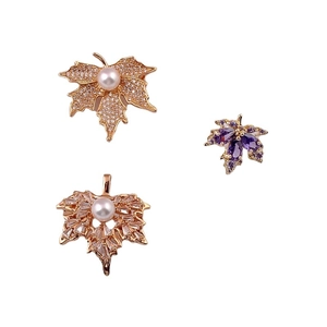 Elegant maple leaf brooches with sparkling zircons, pearls, and purple crystals set in gold