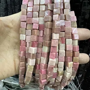 Gros plan de perles carrées en pierre naturelle rose et beige pour création de bijoux