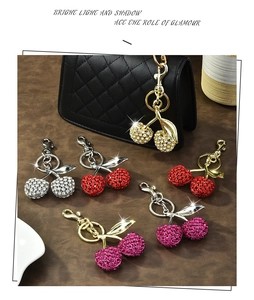 Detailed macro view of sparkling rhinestone cherry keychains with polished alloy swivel hooks