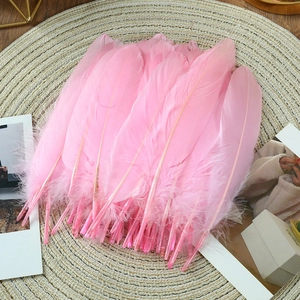 Detailed view of soft pink goose feathers on a woven mat for DIY craft projects