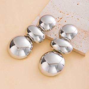 Chic silver tiered spherical drop earrings displayed on a natural stone textured background