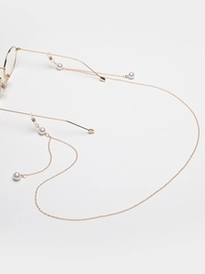 Detail of gold link glasses chain with white pearls and anti-slip rubber loops