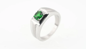 Macro shot of men's silver ring featuring a large emerald-cut green cubic zirconia