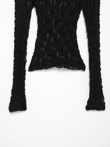 Detail shot of the black long sleeve top showing intricate crinkled fabric texture