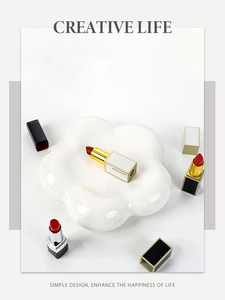 Top view of creative flower-shaped ceramic jewelry tray in cream white with lipsticks