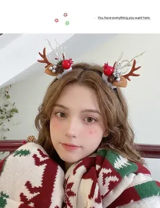 Detail of Christmas reindeer antler hair clips with pine cones and plush base on a model