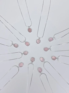 Makroansicht mehrerer S925 Silberhalsketten mit rosa ovalen Chalcedon-Anhängern