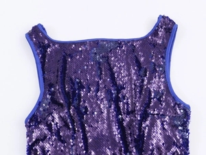 Dettaglio del top con paillettes viola che mostra la scollatura e la trama della spallina