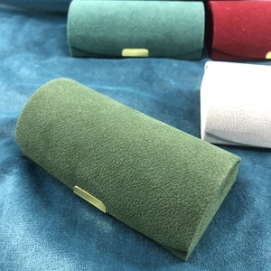 Portable velvet jewelry travel case in moss green, burgundy, and grey with metal clasp