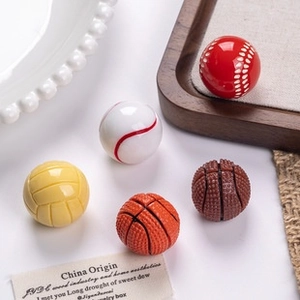 Macro shot of assorted resin sports ball charms including basketball and baseball miniatures