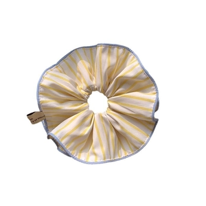 Yellow striped oversized hair scrunchie with blue trim on a clean white background