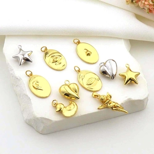 Macro view of assorted gold and silver metal charms including heart, star, and face shapes