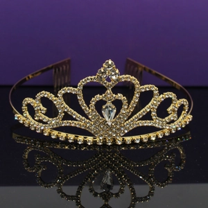 Golden bridal tiara with sparkling rhinestones and teardrop crystal on black mirror
