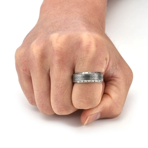 Nahaufnahme eines silbernen Wikinger-Rings mit nordischen Runen und keltischen Knoten