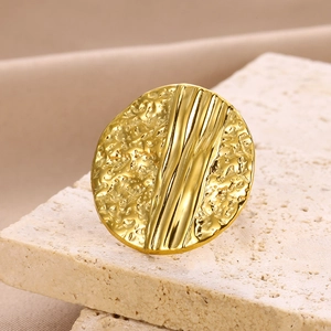 Close-up of golden geometric ring with mixed hammered and vertical striped textures