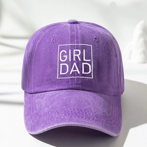 Detailed close-up of white GIRL DAD embroidery on a purple washed cotton baseball cap