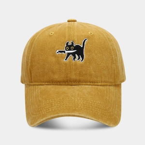 Detailed close-up of a vintage mustard yellow cotton baseball cap with black cat knife embroidery
