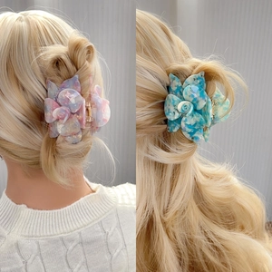 Elegant 3D flower hair claws with pink and blue marble patterns on a female model