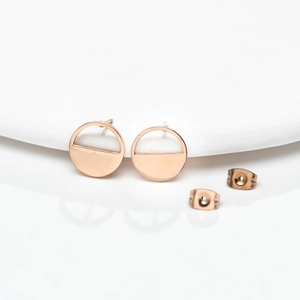Detail of rose gold round earrings with solid and hollow geometric semicircles