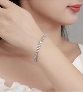 Close-up of sparkling moissanite tennis bracelet on wrist with silver pavé cubic zirconia