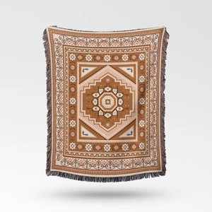 Detail of bohemian geometric knit blanket featuring cotton fringe and earthy tones