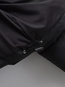 Detailed macro view of the black jacket drawstring with metal eyelet and plastic toggle