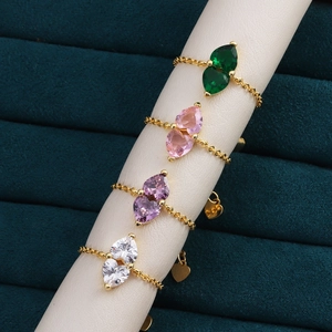 Detailed view of adjustable gold chain rings with double heart-shaped colorful zircons