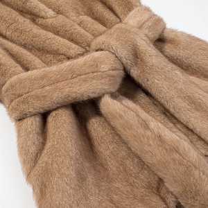 Vue détaillée de la ceinture nouée sur une veste sans manches en fausse fourrure