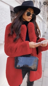 Détail du manteau en fausse fourrure rouge montrant une texture épaisse et brillante