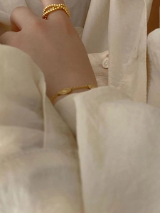 Close-up of 925 sterling silver 18K gold plated beaded ring and sleek chain bracelet