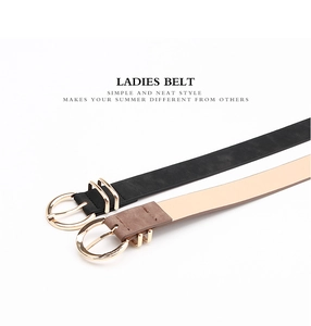 Detail view of black and camel leather belts with gold round buckles on white background