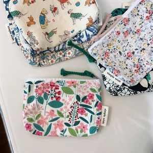 Flat lay view of various floral and cartoon pattern cotton mini pouches with wrist straps