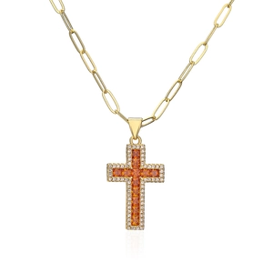 Macro detail of 18K gold paperclip chain and amber zircon cross pendant with sparkling gems