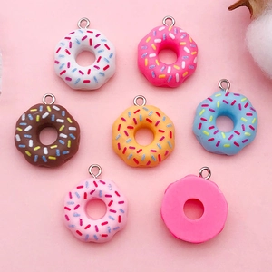 Flat lay of colorful resin donut pendants with sprinkles for DIY jewelry making