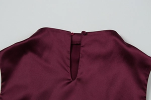 Macro shot of burgundy satin dress neckline with teardrop back opening and button