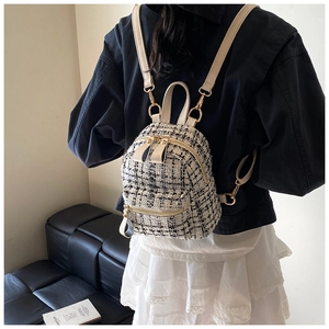Detail of a mini tweed checkered backpack with beige leather straps on model's back