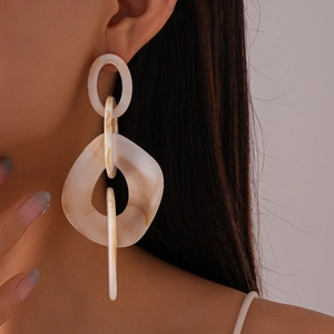 Close-up of geometric cream marble acrylic hollow earrings worn on a model
